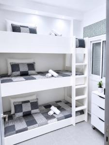 two bunk beds in a room with a window at Résidence Kariat Cabo 2-bedroom apartment in Cabo Negro +28 photos