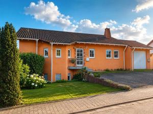 a large orange house with a driveway at Mediterrane Ferienwohnung mit Whirlpool und Weitblick in Merchweiler