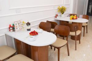 a dining room with white tables and chairs at Anna Noi Bai Airport Hotel in Sóc Sơn