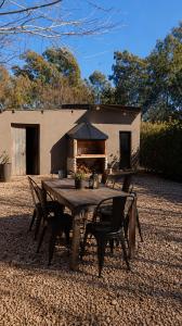 a wooden table and chairs with a fireplace in front of a building at Las Cinco Esquinas in Nueve de Julio