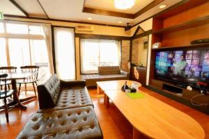a living room with a couch and a tv at ラリックス蓼科 in Chino