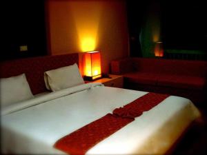 a bedroom with a white bed with a red blanket on it at Panatara Chumphon in Chumphon