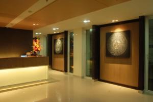a lobby with a wall with a picture of a clock at Panatara Chumphon in Chumphon