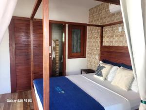 a bedroom with a large bed with a blue bedspread at Casa Verde Canoa Quebrada in Canoa Quebrada +42 photos