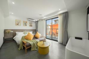 a bedroom with a bed and a couch and a window at 贵客心宿 Xiamen Guike Xinsu in Xiamen +61 photos