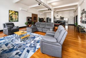 a living room with two couches and a table at The Nelson Loft - Sauna, Balcony & City Centre Living in Nelson