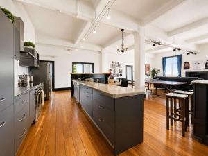 a large kitchen with a large counter and a table at The Nelson Loft - Sauna, Balcony & City Centre Living in Nelson