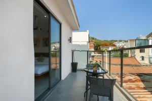 a balcony with a table and chairs and a bed at 贵客心宿 Xiamen Guike Xinsu in Xiamen