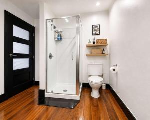 a bathroom with a shower and a toilet at The Nelson Loft - Sauna, Balcony & City Centre Living in Nelson +15 photos