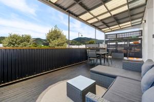 a patio with a table and chairs on a balcony at The Nelson Loft - Sauna, Balcony & City Centre Living in Nelson