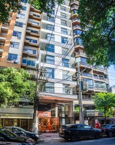 a tall building with cars parked in front of it at Loft Icarai in Niterói