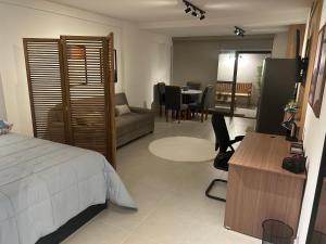a bedroom with a bed and a living room with a table at Loft Icarai in Niterói +27 photos