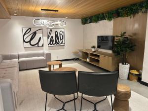 a living room with a couch and chairs at Loft Icarai in Niterói