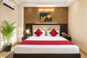 a bedroom with a large bed with red pillows at The Vanta Luxe Near Yashobhumi in New Delhi