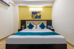 a bedroom with a large bed with blue pillows at The Vanta Luxe Near Yashobhumi in New Delhi