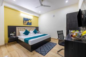 a bedroom with a bed and a desk and a television at The Vanta Luxe Near Yashobhumi in New Delhi +7 photos