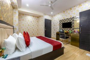 a bedroom with a bed and a desk and a television at The Vanta Luxe Near Yashobhumi in New Delhi