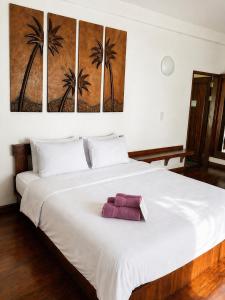 a bedroom with a large white bed with palm trees on it at Villa Formosa Panglao in Panglao Island