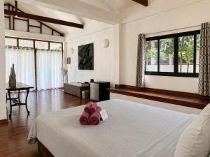 a bedroom with a bed with pink flowers on it at Villa Formosa Panglao in Panglao Island