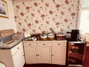 a kitchen with a counter with flowers on the wall at SmartsWay Hotel & Wellness in Eastbourne +13 photos