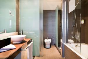 a bathroom with a sink and a toilet and a shower at Hotel Barcelona Condal Mar, Affiliated by Meliá in Barcelona