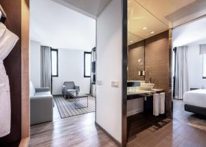 a hotel room with a bathroom and a bedroom at Hotel Barcelona Condal Mar, Affiliated by Meliá in Barcelona