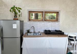 a kitchen with a sink and a refrigerator at Sanghiang Homestay in Batukaras +22 photos