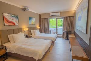 a hotel room with two beds and a large screen at EGI Cebu Resort and Hotel in Maribago