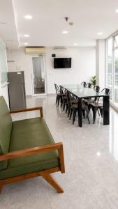 a dining room with a green couch and a table at Merryland ICE BSD City in Tjilandak