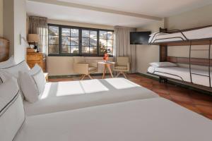 a bedroom with a large white bed and a living room at Meliá Sol y Nieve in Sierra Nevada +114 photos