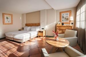 a hotel room with a bed and a table at Meliá Sol y Nieve in Sierra Nevada