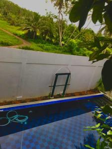 a swimming pool with a towel rack next to a white wall at Pedlar Bungalow in Talpe +67 photos