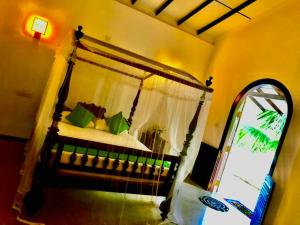 a bedroom with a swinging bed with a window at Pedlar Bungalow in Talpe
