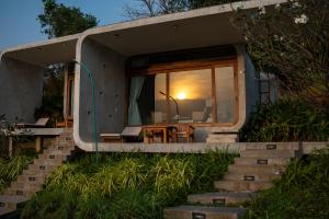a tiny house with a staircase leading to the entrance at La Plantation Villa in Kampot