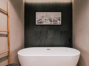 a white tub in a bathroom with a picture on the wall at MiM Baqueira member of Meliá Collection in Baqueira-Beret