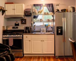 a kitchen with a stainless steel refrigerator and a sink at Blackberry Bunkhouse in Ashford