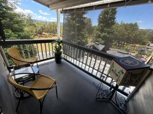 a balcony with two chairs and a box on it at Two Sisters Inn at the Courtyard in Ahwahnee