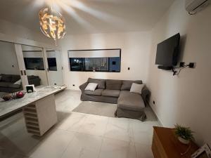 a living room with a couch and a tv at Apartamento completo punta cana in Punta Cana