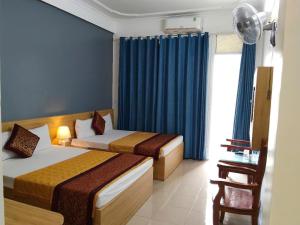 a hotel room with two beds and a window at Khách sạn Đại Huệ in Dong Quan