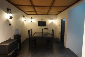 ein Zimmer mit einem Tisch mit Stühlen und einem Fernseher in der Unterkunft Ward 58 in Wellawaya