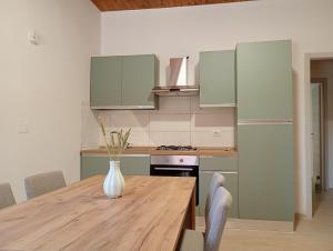 a kitchen with a wooden table with a vase on it at Casa Marina mare e relax in Marina Palmense