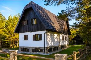an old white house with a black roof at Timber valley in Plitvička Jezera