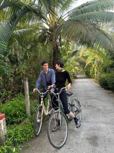 a man and a woman riding a bike down a road at Haven Nest Retreat in Ấp Phú Hòa (3)