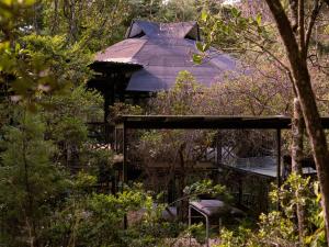 a house with a roof in the middle of a forest at Must Go Centro de Bienestar in Medellín