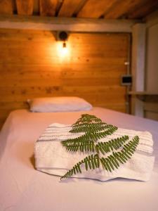 a towel with a plant on top of a bed at Must Go Centro de Bienestar in Medellín