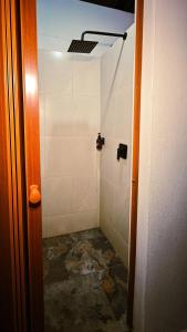 a bathroom with a shower with a tiled floor at Must Go Centro de Bienestar in Medellín