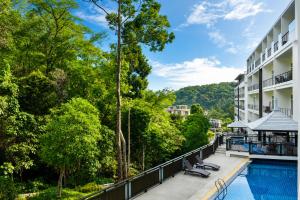 an exterior view of a resort with a swimming pool and trees at Grand Kamala Falls in Kamala Beach