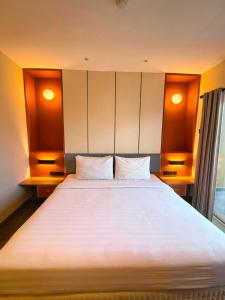 a bedroom with a large white bed with two pillows at Marra Hotel in Yogyakarta
