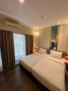 a hotel room with two beds and a window at Marra Hotel in Yogyakarta