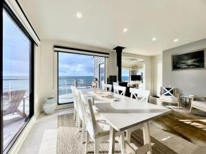 a dining room with a table and a view of the ocean at The Mariner - Oceanfront Living in Falmouth